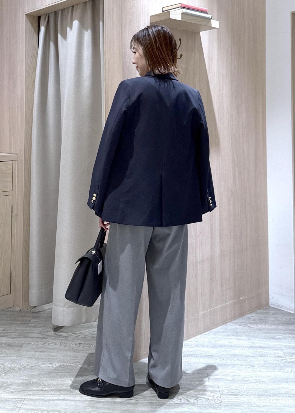 グレー系のその他パンツ、ブルー系のテーラードジャケット、ブラック系のハンドバッグを着用したレディースの冬コーディネートの3枚目の写真