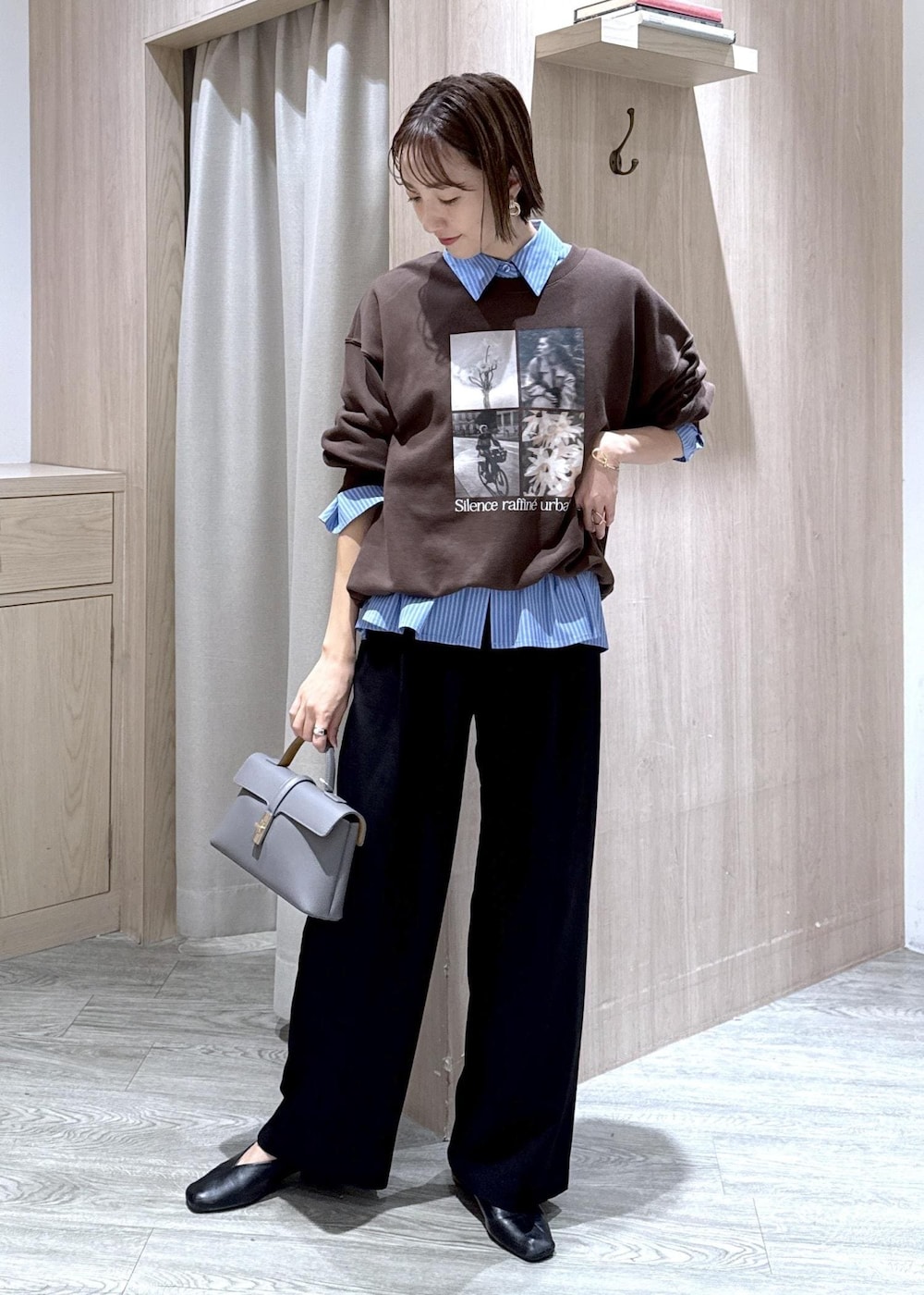 グレー系のショルダーバッグ、ブラック系のスラックス、ブルー系のシャツ/ブラウスを着用したレディースの秋コーディネートの3枚目の写真