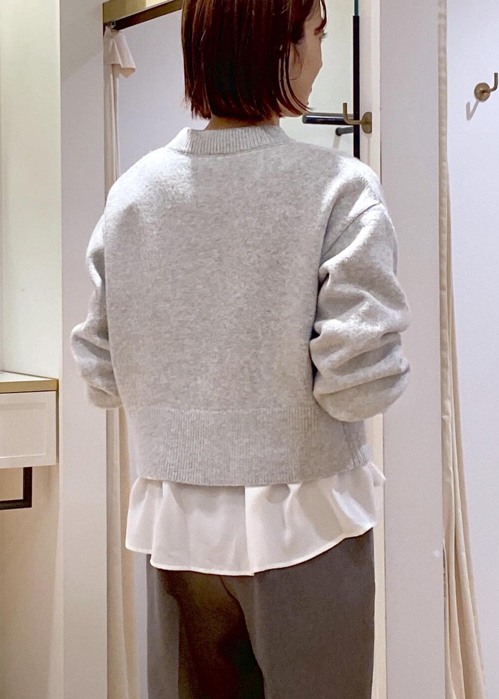 ホワイト系のブーツ、ホワイト系のシャツ/ブラウス、グレー系のカーディガン/ボレロを着用したレディースの冬コーディネートの8枚目の写真