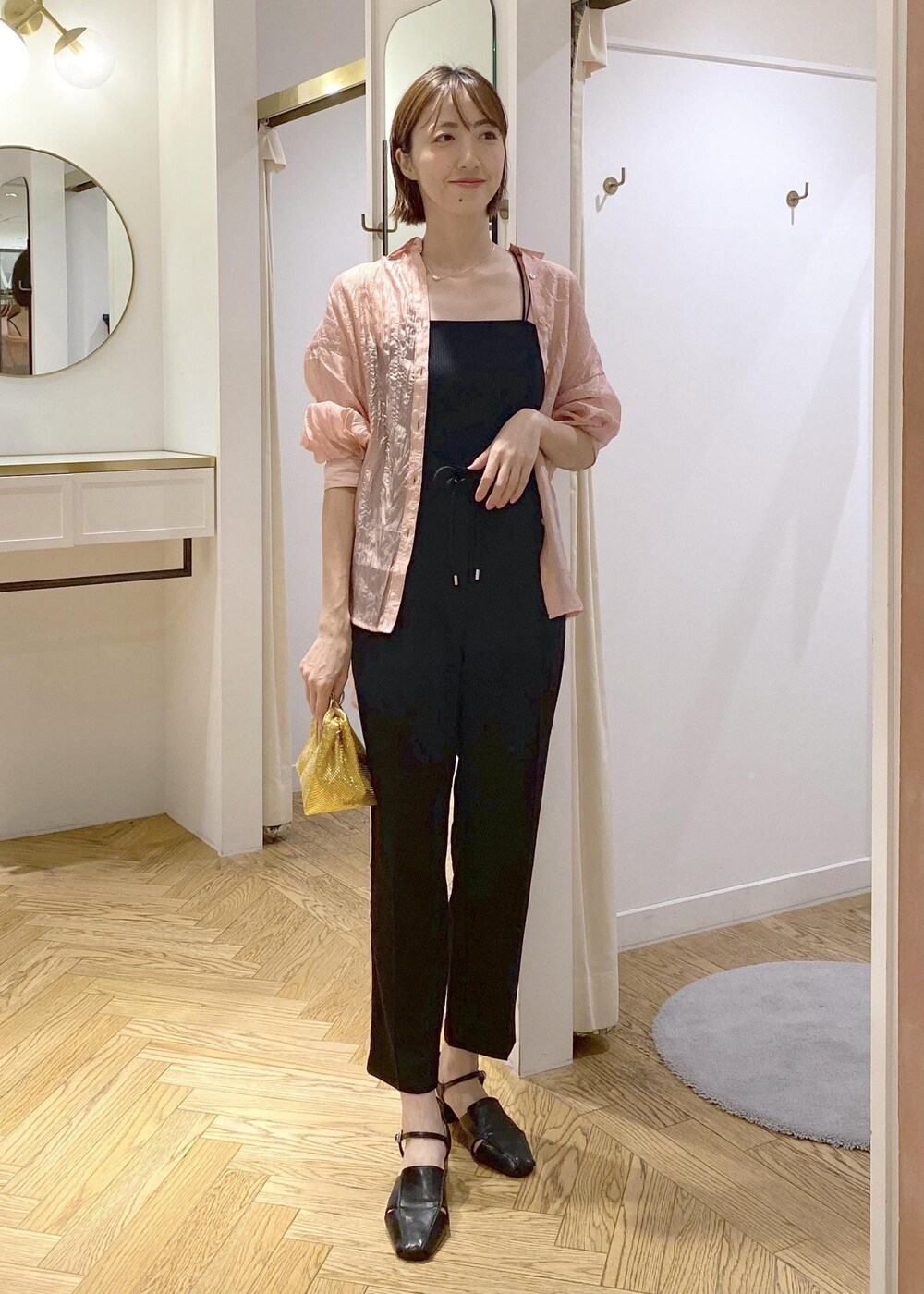 ブラック系のサンダル、ブラック系のスラックス、ブラック系のキャミソールを着用したレディースの夏コーディネートの7枚目の写真