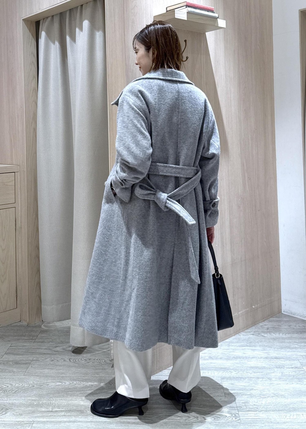 ブラック系のショルダーバッグ、グレー系のその他アウター、ホワイト系のスラックスを着用したレディースの冬コーディネートの4枚目の写真