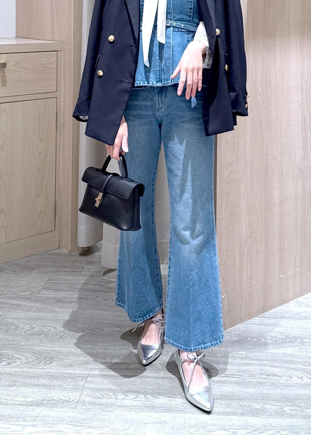 ブラック系のショルダーバッグ、ブルー系のキャミソール、ブルー系のテーラードジャケットを着用したレディースの冬コーディネートの5枚目の写真