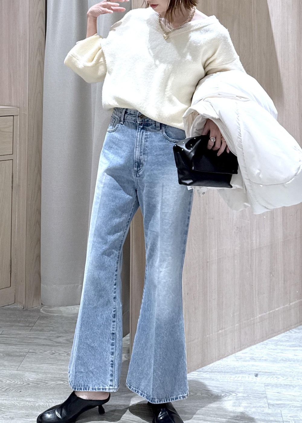 ホワイト系のダウンジャケット/コート、ブラック系のショルダーバッグ、ホワイト系のニット/セーターを着用したレディースの冬コーディネートの5枚目の写真