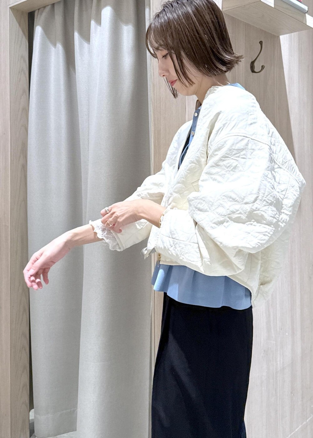 ブラック系のスラックス、ブラック系のショルダーバッグ、ブルー系のカーディガン/ボレロを着用したレディースの秋コーディネートの7枚目の写真