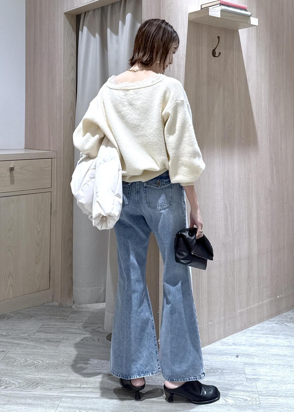 ホワイト系のダウンジャケット/コート、ブラック系のショルダーバッグ、ホワイト系のニット/セーターを着用したレディースの冬コーディネートの3枚目の写真