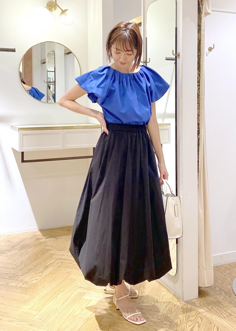 ブラック系のキャミソール、ホワイト系のサンダル、ブラック系のスカートを着用したレディースの春コーディネートの4枚目の写真