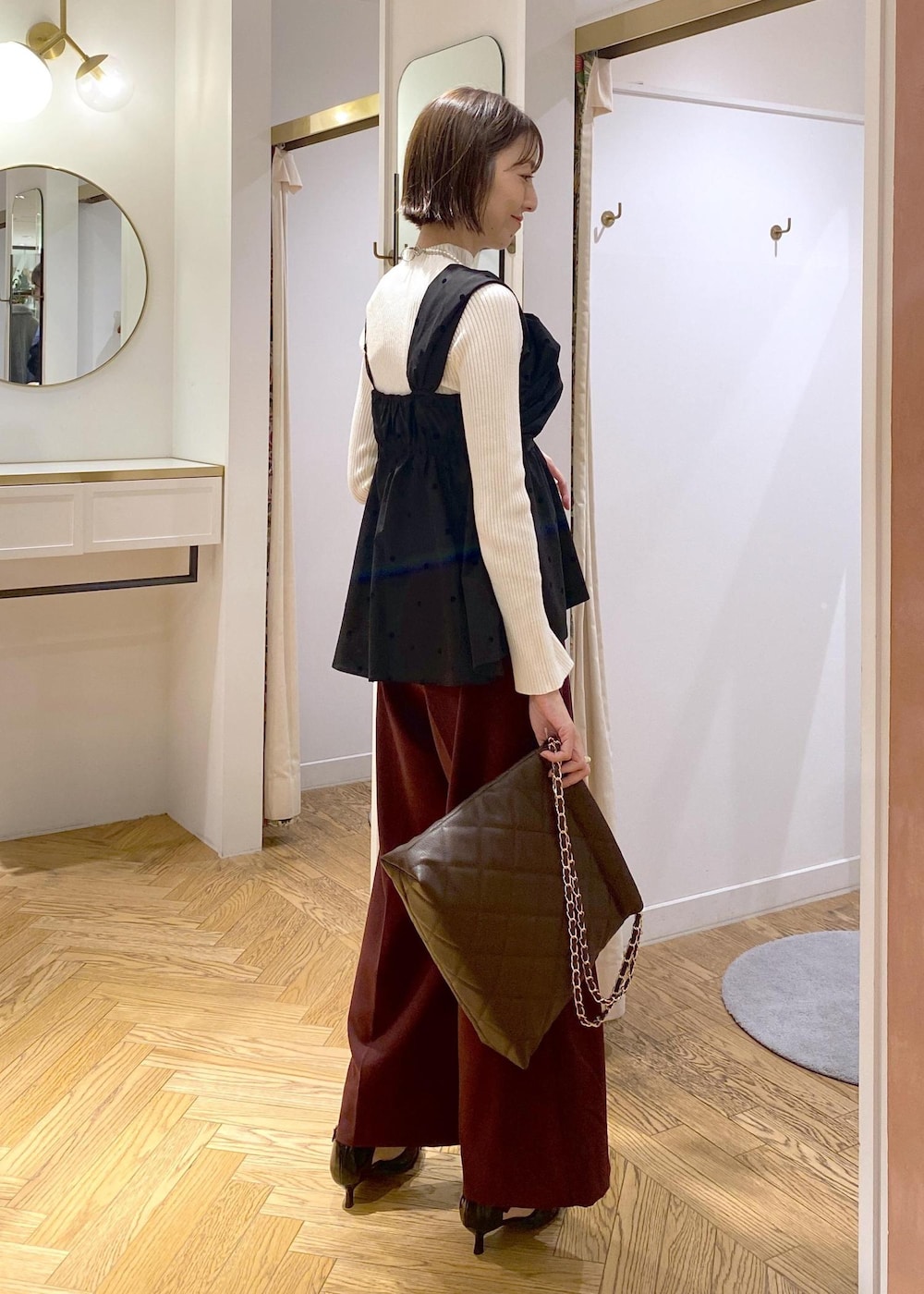 ブラック系のパンプス、ブラック系のキャミソール、ホワイト系のニット/セーターを着用したレディースの冬コーディネートの3枚目の写真