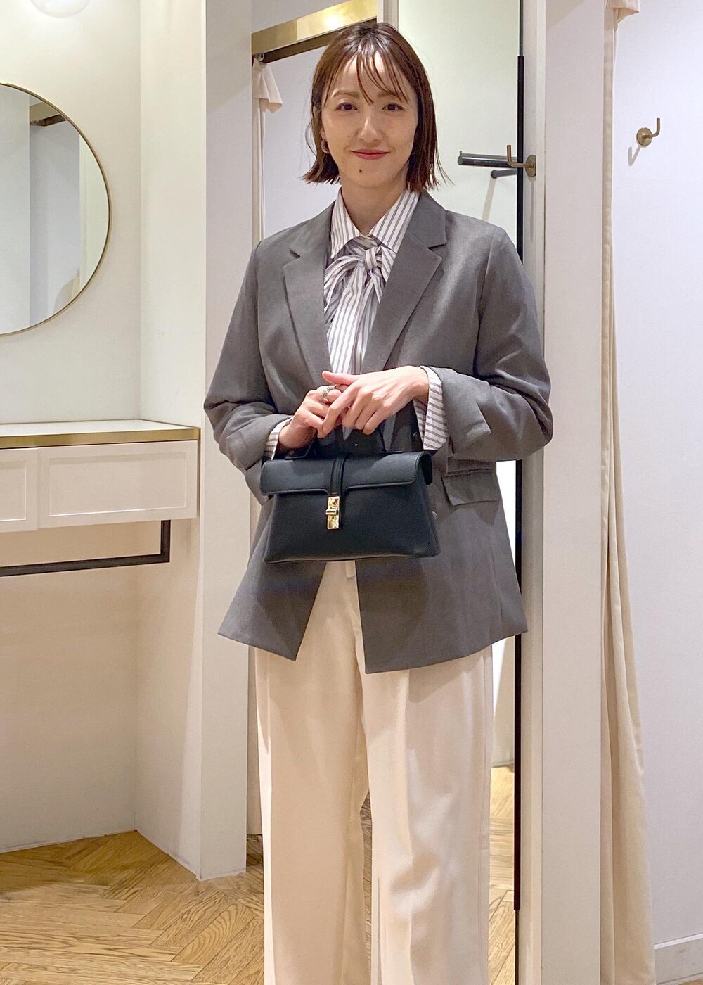 シルバー系のパンプス、ホワイト系のシャツ/ブラウス、ホワイト系のスラックスを着用したレディースの冬コーディネートの6枚目の写真