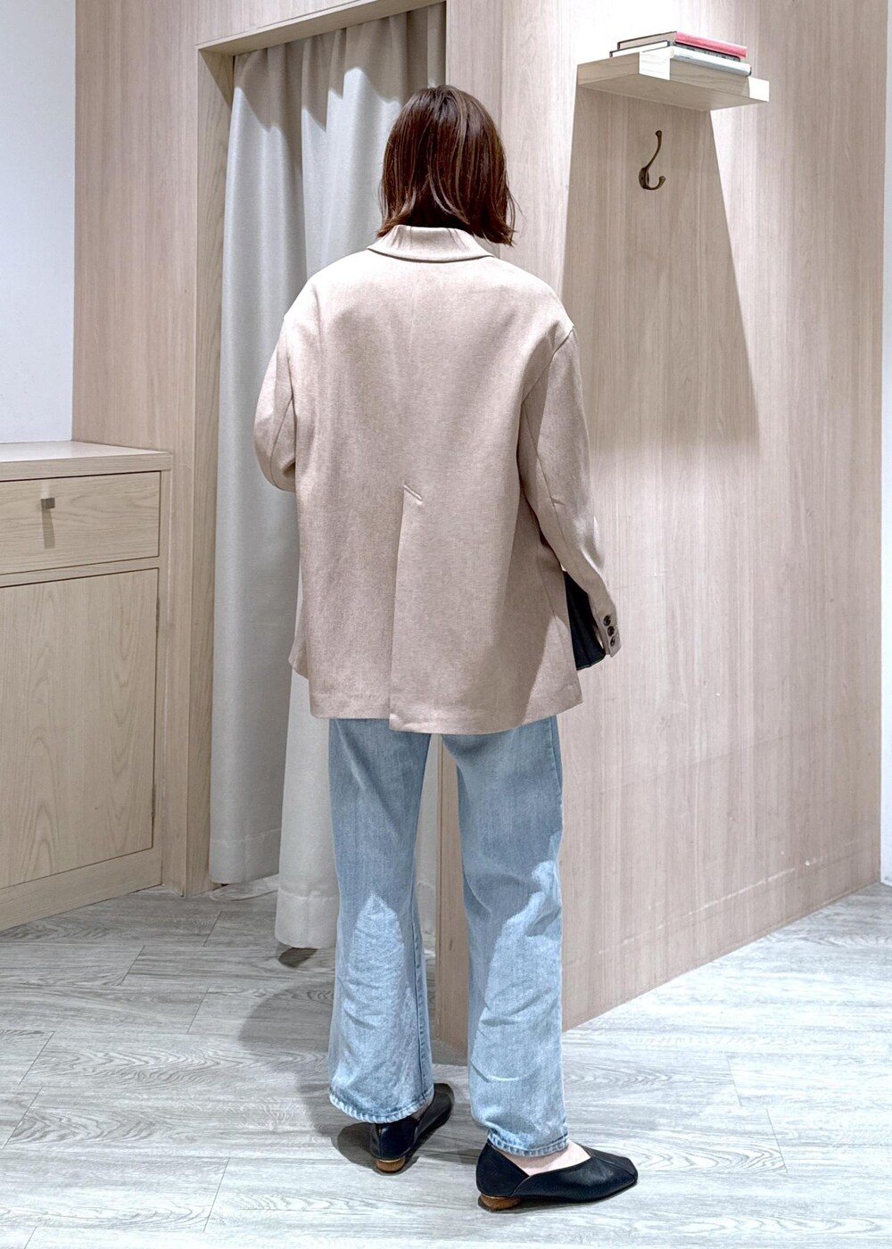 ブラック系のショルダーバッグ、ブルー系のデニムパンツ、イエロー系のテーラードジャケットを着用したレディースの春コーディネートの4枚目の写真