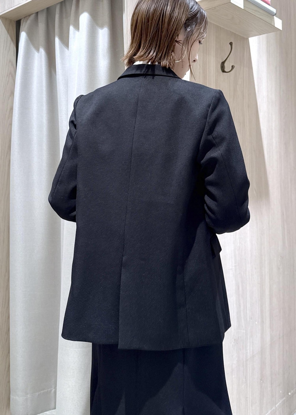 ブラック系のショルダーバッグ、ブラック系のスカート、ブラック系のテーラードジャケットを着用したレディースの冬コーディネートの10枚目の写真