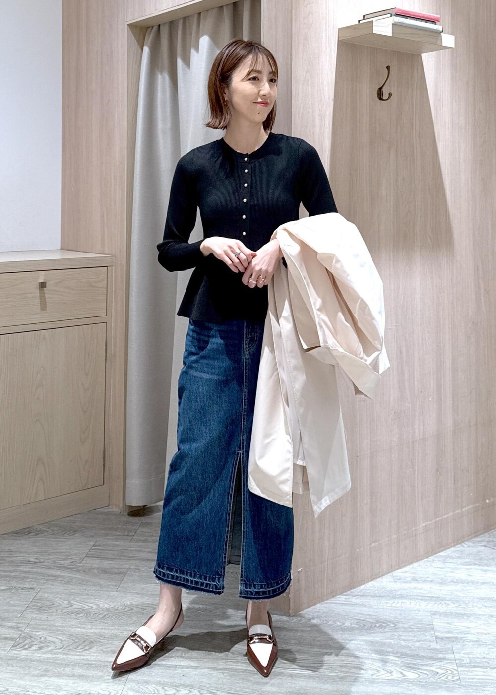 ブラック系のショルダーバッグ、ブラウン系のパンプス、ブルー系のデニムスカートを着用したレディースの春コーディネートの9枚目の写真