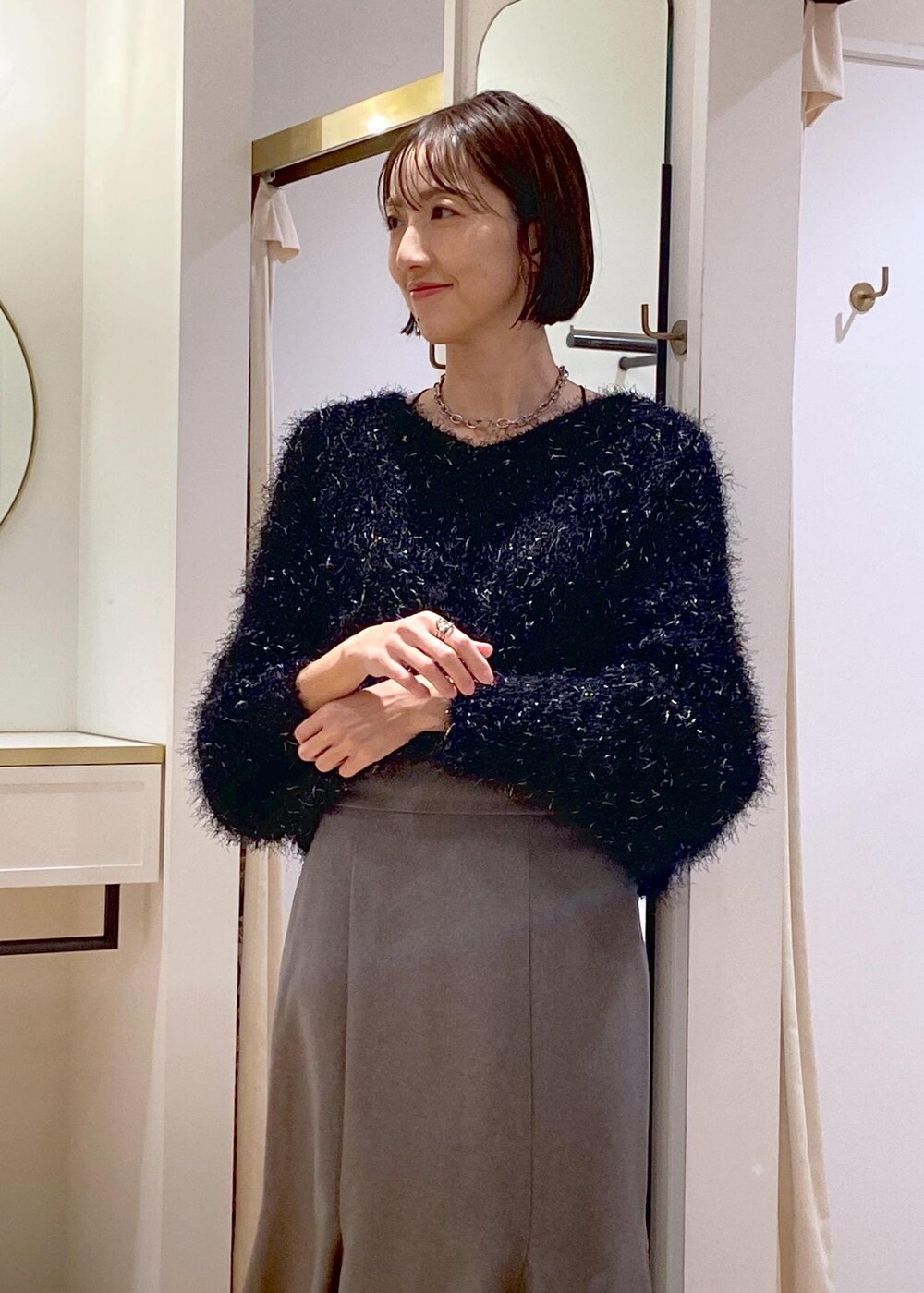 ホワイト系のブーツ、グレー系のスカート、ホワイト系のダウンジャケット/コートを着用したレディースの冬コーディネートの9枚目の写真