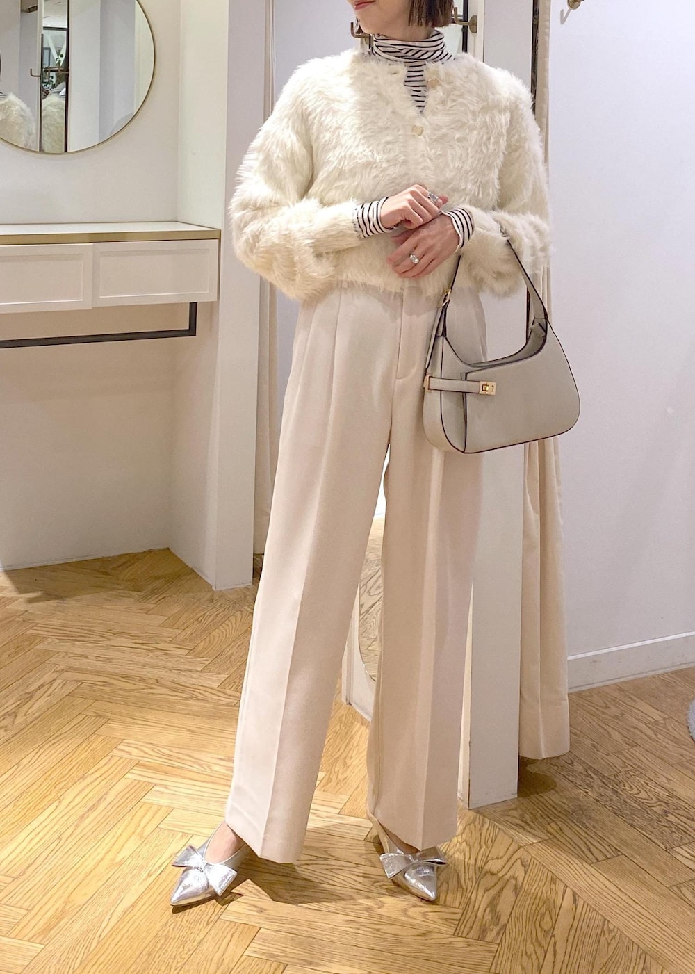 シルバー系のパンプス、ホワイト系のカーディガン/ボレロ、ホワイト系のTシャツ/カットソーを着用したレディースの冬コーディネートの5枚目の写真