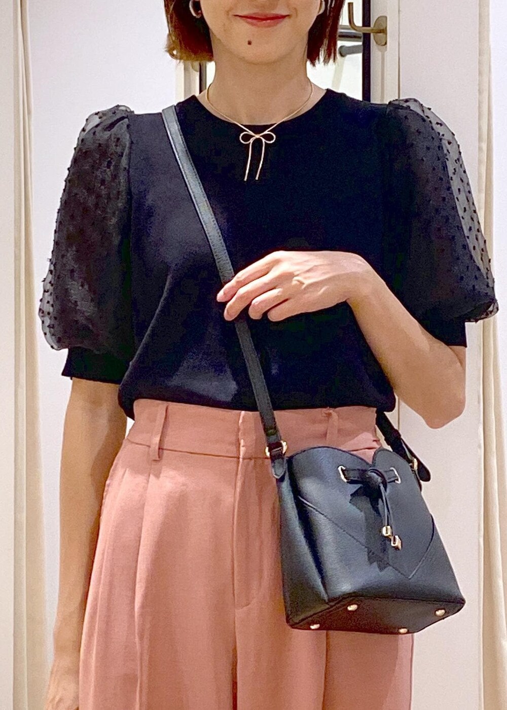 ブラック系のローファー、ブラック系のニット/セーター、ピンク系のスラックスを着用したレディースの夏コーディネートの5枚目の写真