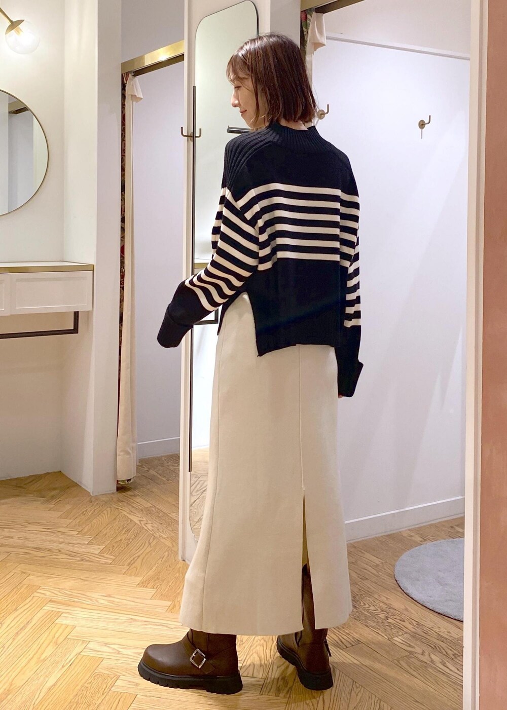 ブラック系のショルダーバッグ、ブラウン系のブーツ、ブラック系のニット/セーターを着用したレディースの秋コーディネートの8枚目の写真