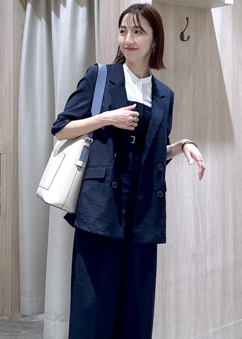 ベージュ系のトートバッグ、ホワイト系のパンプス、ブルー系のシャツ/ブラウスを着用したレディースの夏コーディネートの5枚目の写真