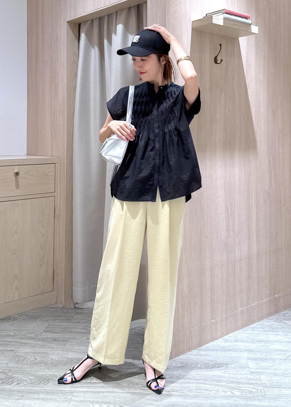 ブラック系のサンダル、イエロー系のスラックス、ブラック系のシャツ/ブラウスを着用したレディースの夏コーディネートの10枚目の写真