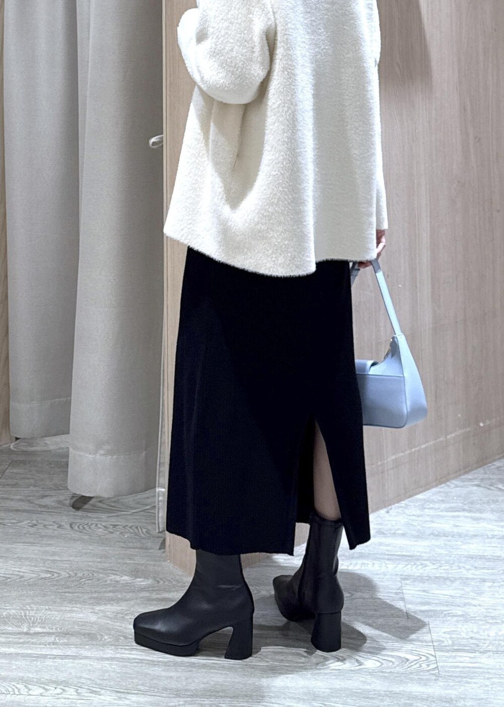 ブルー系のハンドバッグ、ホワイト系のノーカラージャケット、ブラック系のブーツを着用したレディースの秋コーディネートの6枚目の写真