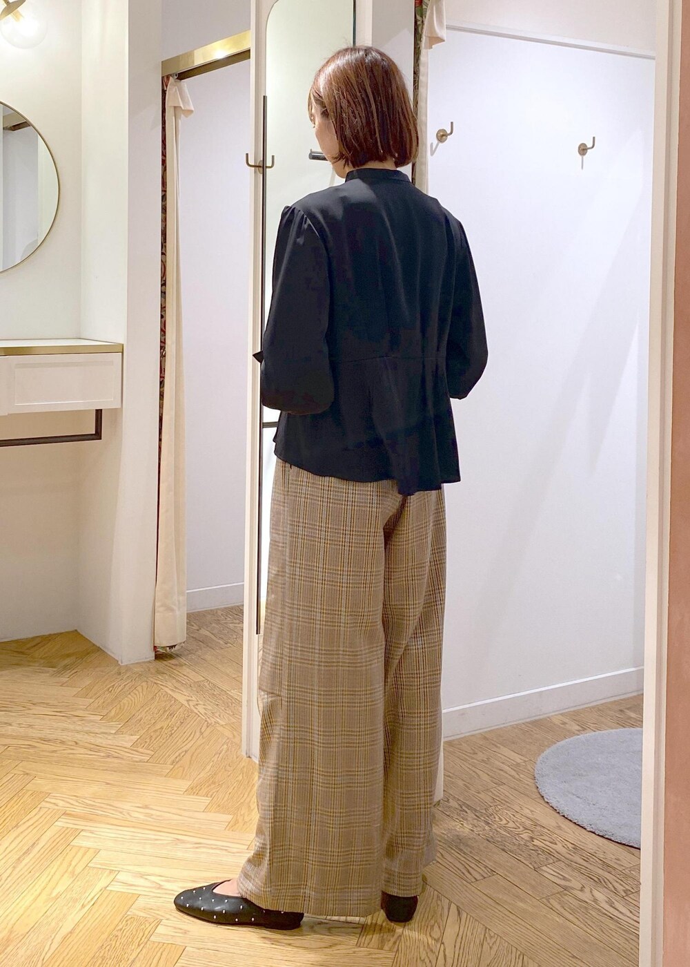 グレー系のテーラードジャケット、ブラック系のバレエシューズ、ベージュ系のトートバッグを着用したレディースの秋コーディネートの7枚目の写真