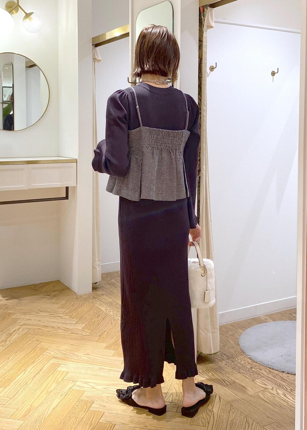 ブラック系のサンダル、ブラック系のワンピース、ホワイト系のショルダーバッグを着用したレディースの秋コーディネートの2枚目の写真