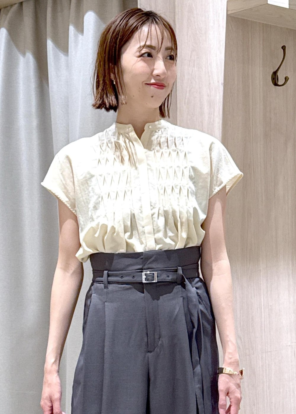 ブラック系のショルダーバッグ、ブラック系のパンプス、ホワイト系のカーディガン/ボレロを着用したレディースの夏コーディネートの6枚目の写真