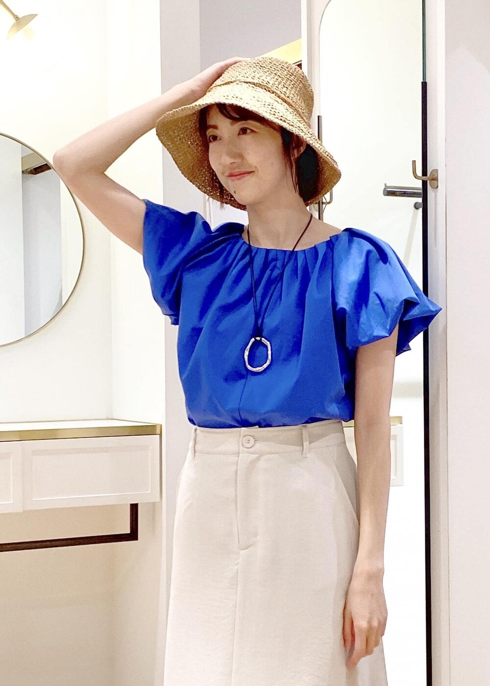 ブラック系のキャミソール、ブラック系のサンダル、ホワイト系のスカートを着用したレディースの春コーディネートの4枚目の写真