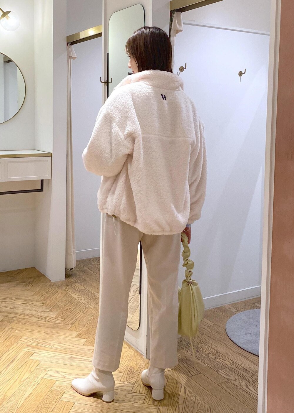 ホワイト系のブーツ、ホワイト系のブルゾン、ブルー系のニット/セーターを着用したレディースの冬コーディネートの4枚目の写真