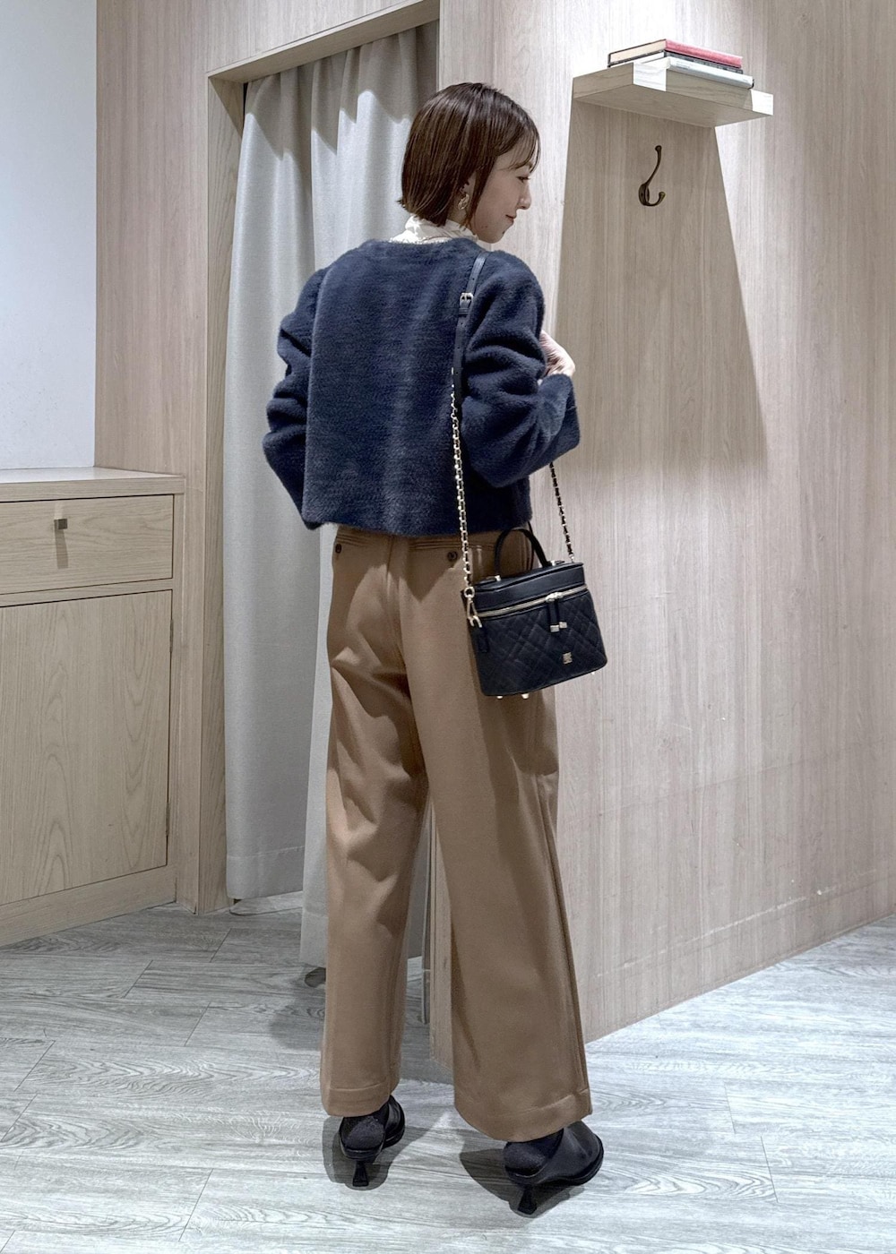 ブルー系のカーディガン/ボレロ、ホワイト系のTシャツ/カットソー、ブラック系のブーツを着用したレディースの冬コーディネートの3枚目の写真