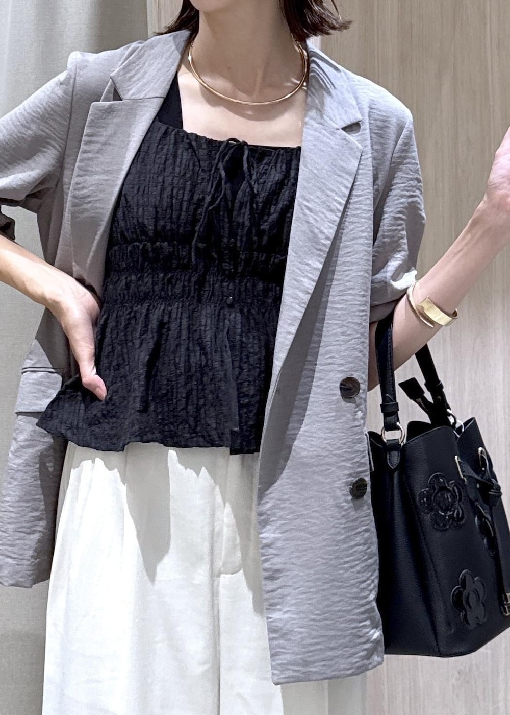グレー系のテーラードジャケット、ホワイト系のその他パンツ、ブラック系のキャミソールを着用したレディースの夏コーディネートの9枚目の写真
