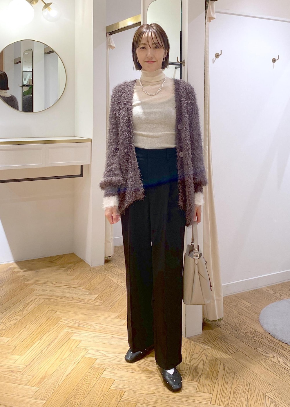 ブラック系のバレエシューズ、グレー系のカーディガン/ボレロ、ホワイト系のニット/セーターを着用したレディースの秋コーディネートの9枚目の写真