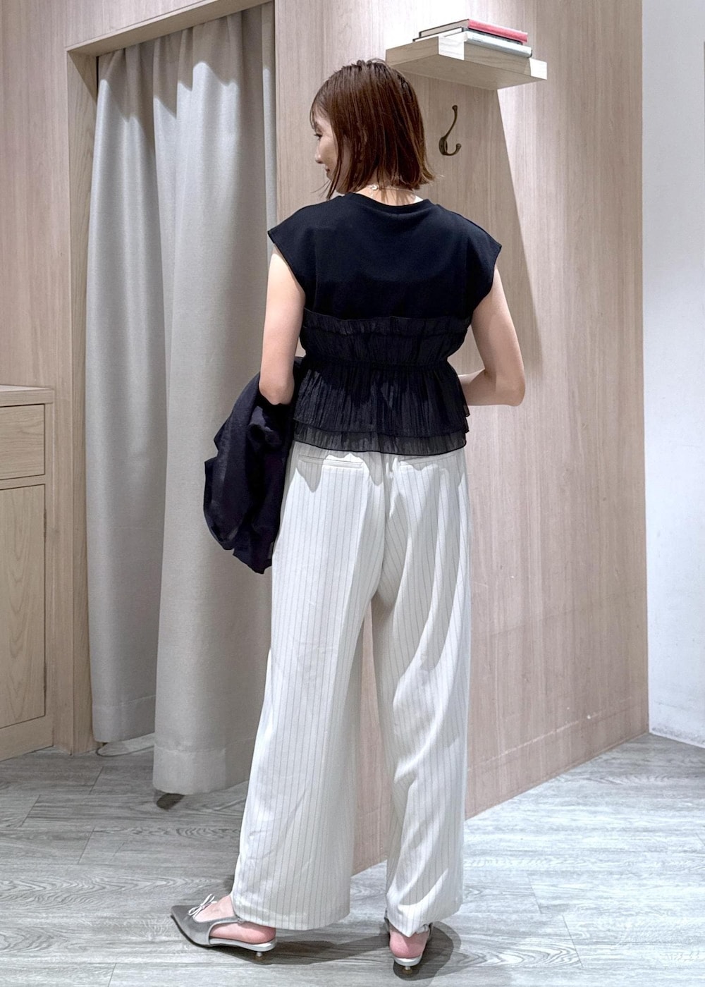 グレー系のショルダーバッグ、シルバー系のパンプス、ブラック系のTシャツ/カットソーを着用したレディースの夏コーディネートの9枚目の写真