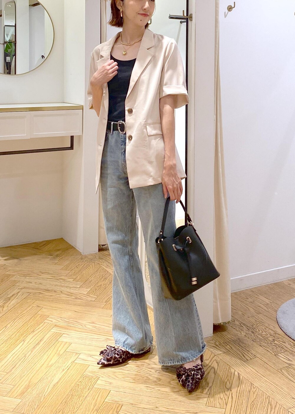 ブラック系のキャミソール、ホワイト系のテーラードジャケット、その他のサンダルを着用したレディースの夏コーディネートの3枚目の写真