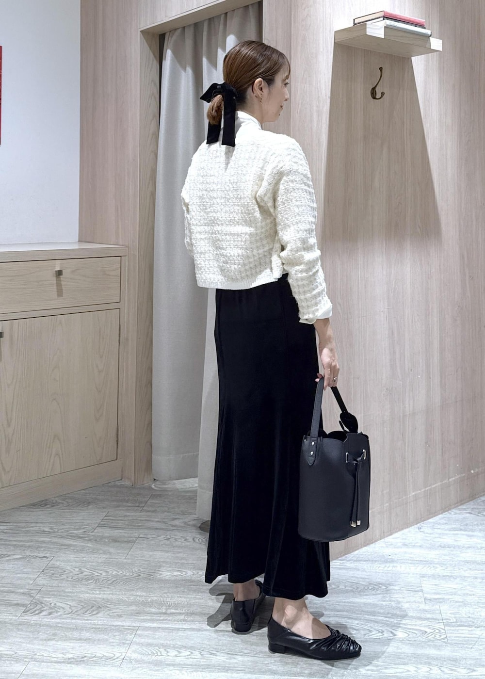 ブラック系のパンプス、ホワイト系のカーディガン/ボレロ、ブラック系のショルダーバッグを着用したレディースの秋コーディネートの3枚目の写真