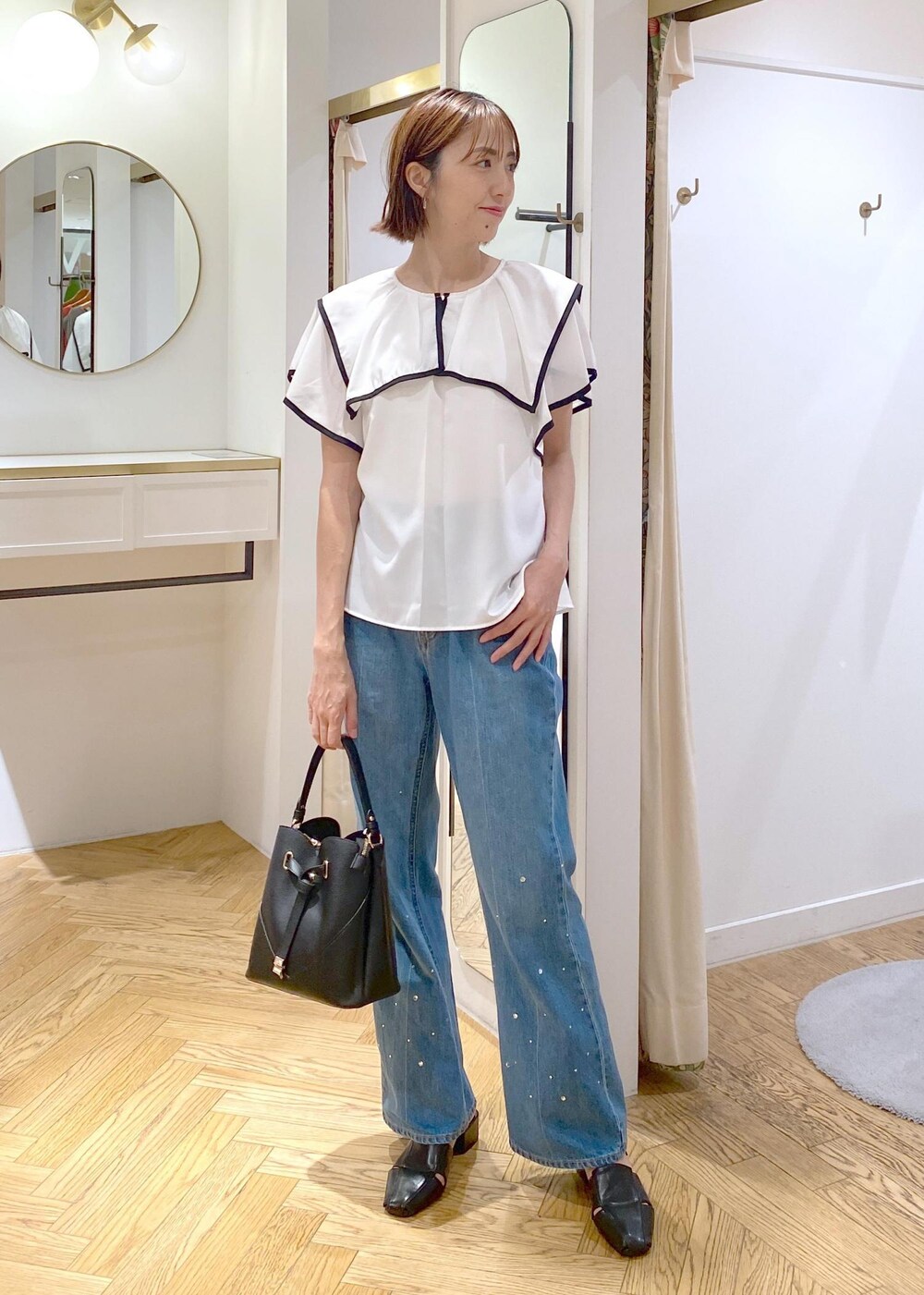 ブラック系のサンダル、ホワイト系のキャミソール、ブルー系のデニムパンツを着用したレディースの夏コーディネートの8枚目の写真