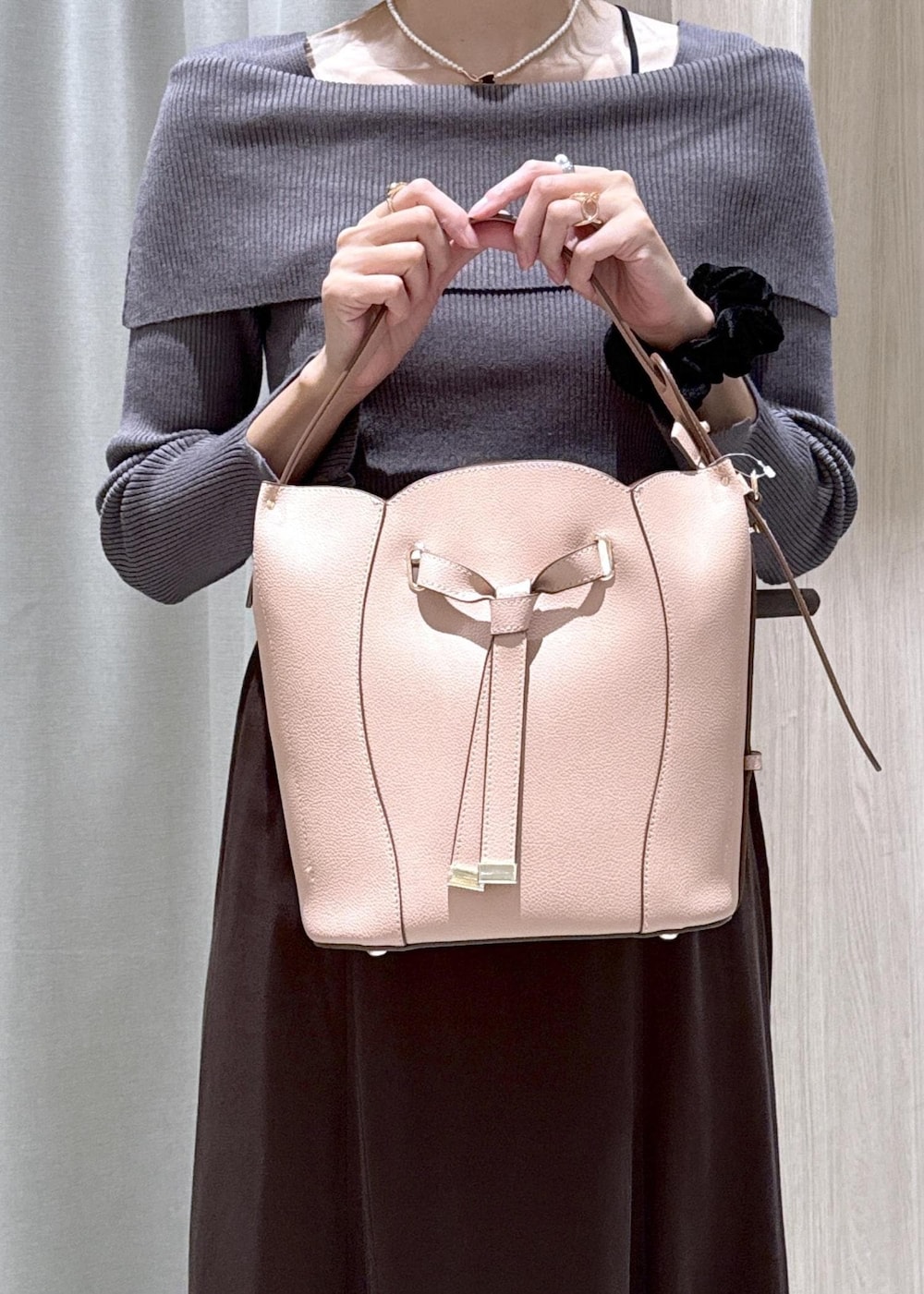 ホワイト系のパンプス、ブラウン系のスカート、グレー系のニット/セーターを着用したレディースの秋コーディネートの7枚目の写真