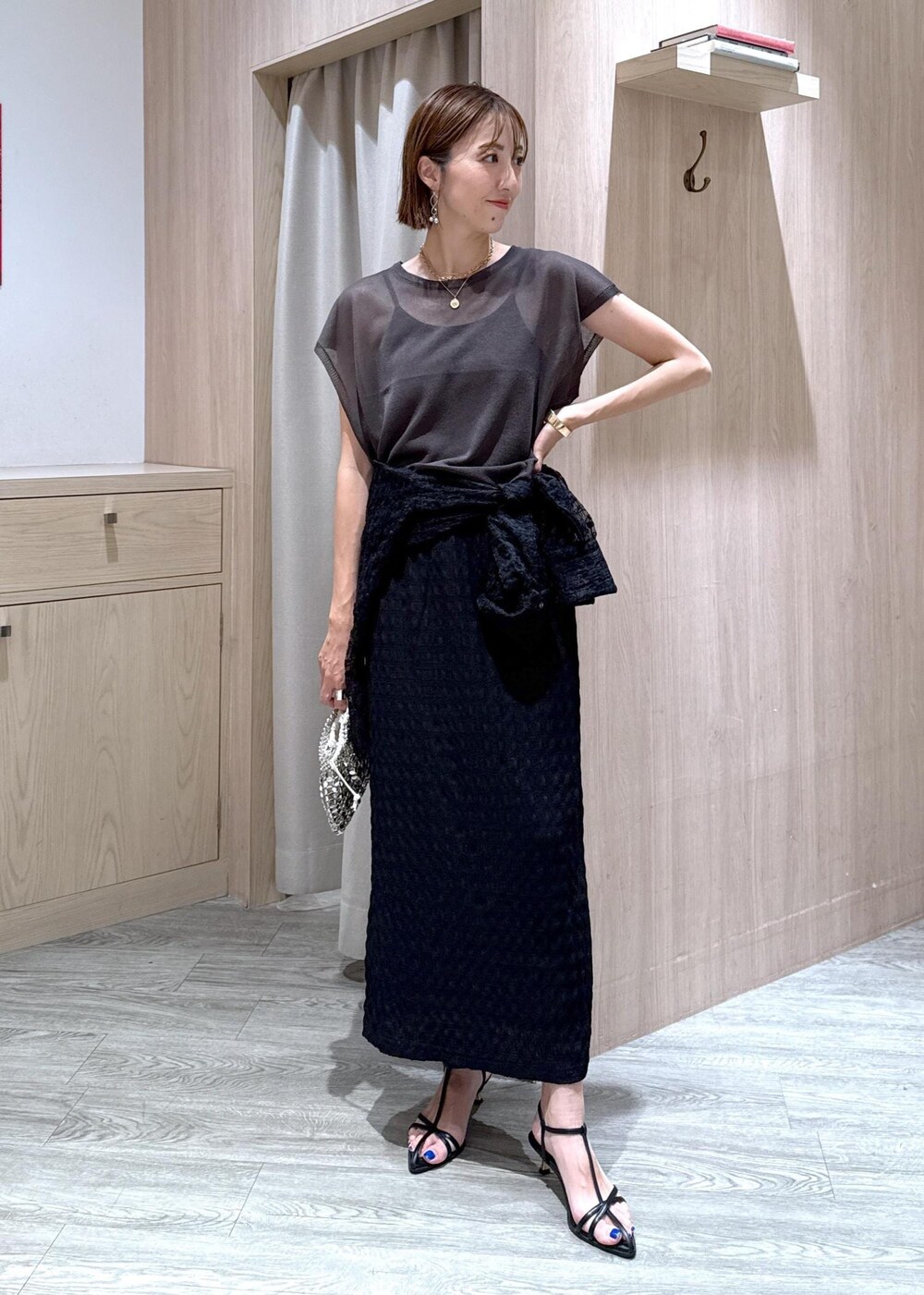 ブラック系のサンダル、シルバー系のハンドバッグ、ブラック系のシャツ/ブラウスを着用したレディースの夏コーディネートの5枚目の写真