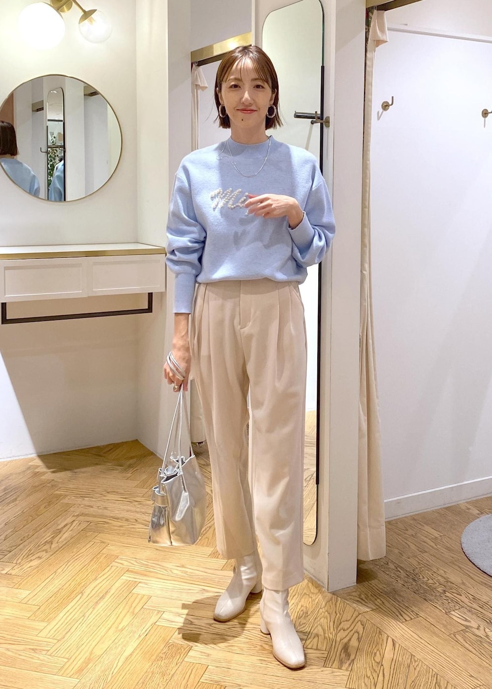 ホワイト系のブーツ、ブルー系のニット/セーター、ベージュ系のその他パンツを着用したレディースの冬コーディネートの2枚目の写真