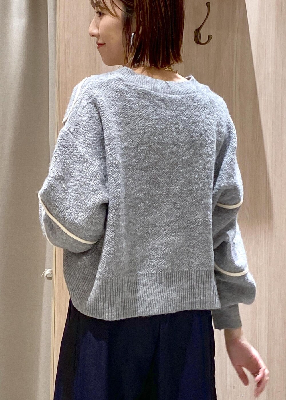 ブラック系のパンプス、グレー系のニット/セーター、ホワイト系のトートバッグを着用したレディースの冬コーディネートの9枚目の写真