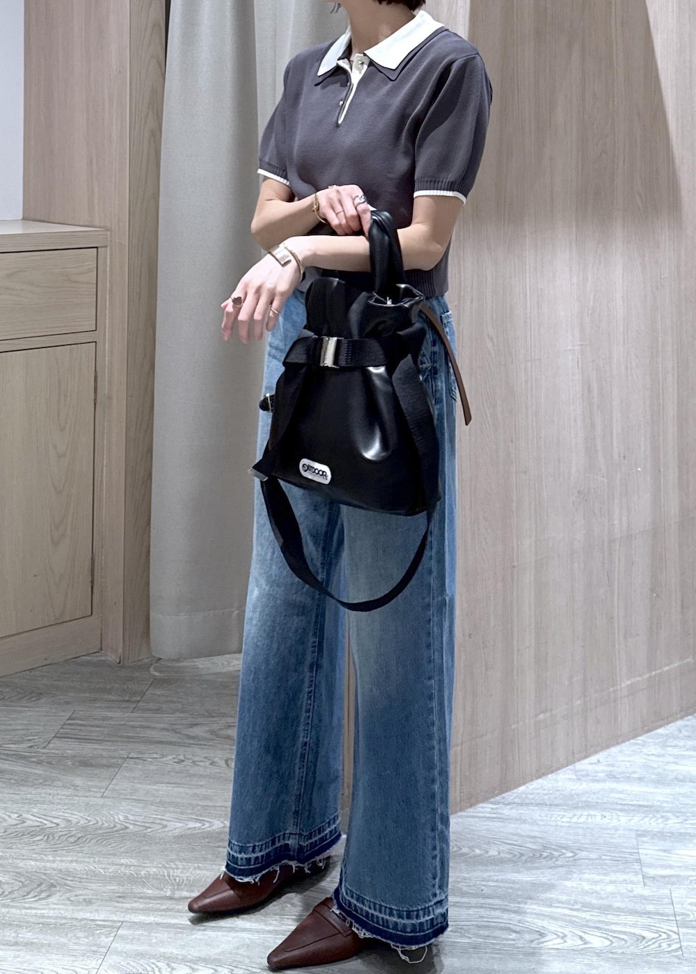 ホワイト系のキャミソール、ブラック系のトートバッグ、ブルー系のデニムパンツを着用したレディースの春コーディネートの10枚目の写真