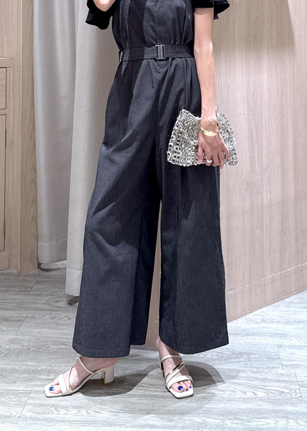 ホワイト系のサンダル、ブラック系のシャツ/ブラウス、シルバー系のハンドバッグを着用したレディースの夏コーディネートの5枚目の写真