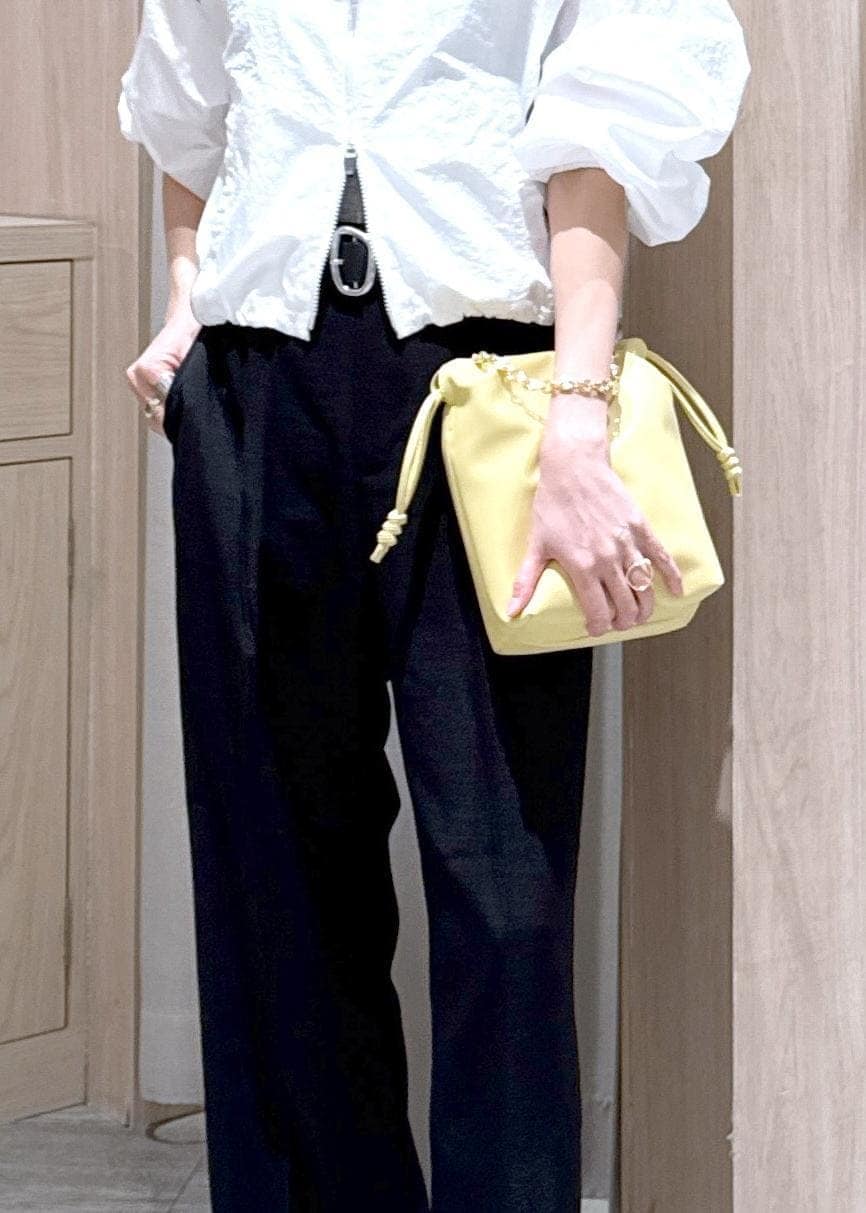 グレー系のタンクトップ、ブラック系のサンダル、ブラック系のスラックスを着用したレディースの春コーディネートの9枚目の写真