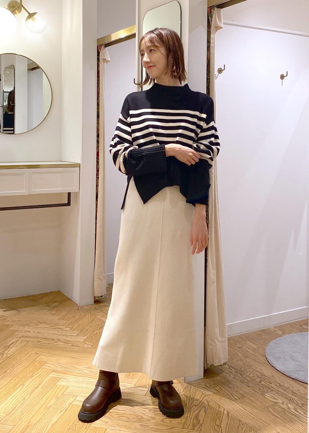 ブラック系のショルダーバッグ、ブラウン系のブーツ、ブラック系のニット/セーターを着用したレディースの秋コーディネートの7枚目の写真