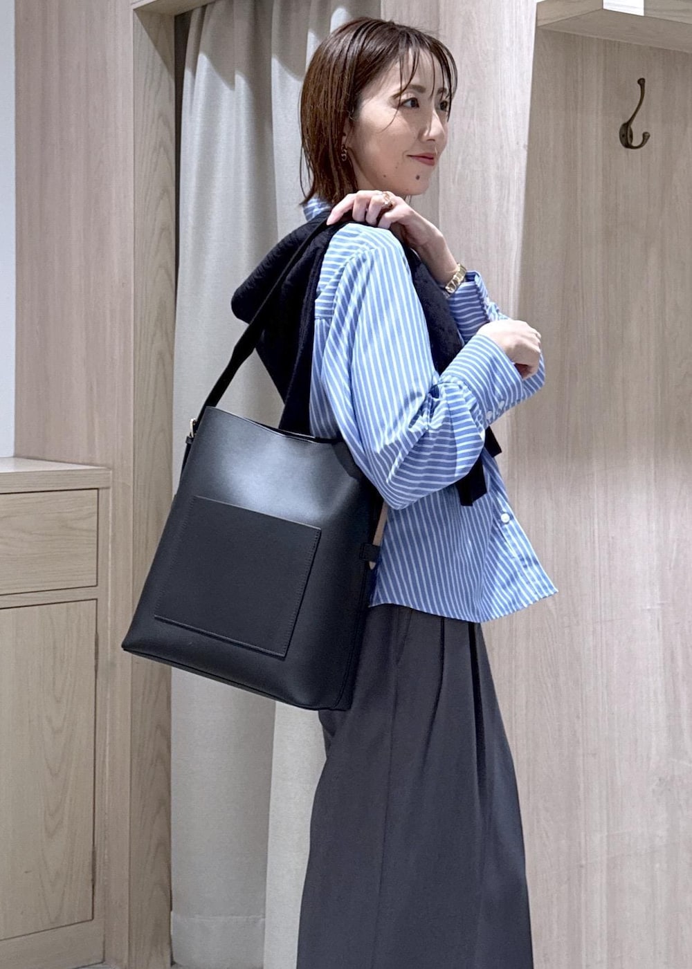 ブラック系のトートバッグ、ブルー系のカーディガン/ボレロ、グレー系のその他パンツを着用したレディースの冬コーディネートの5枚目の写真