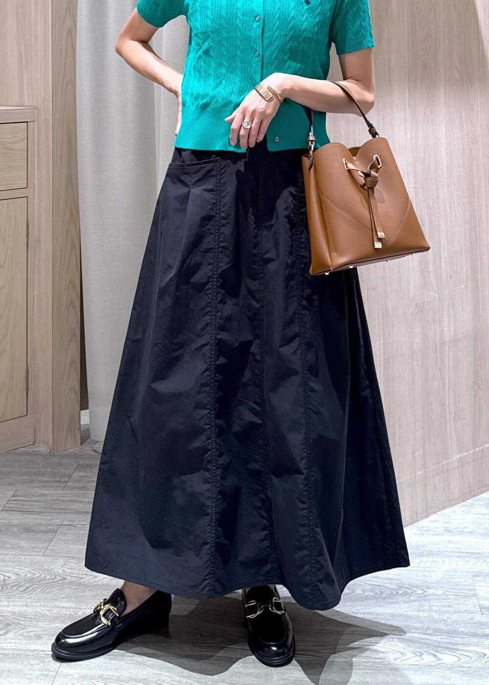 ブラック系のローファー、グリーン系のカーディガン/ボレロ、ブラウン系のショルダーバッグを着用したレディースの夏コーディネートの5枚目の写真