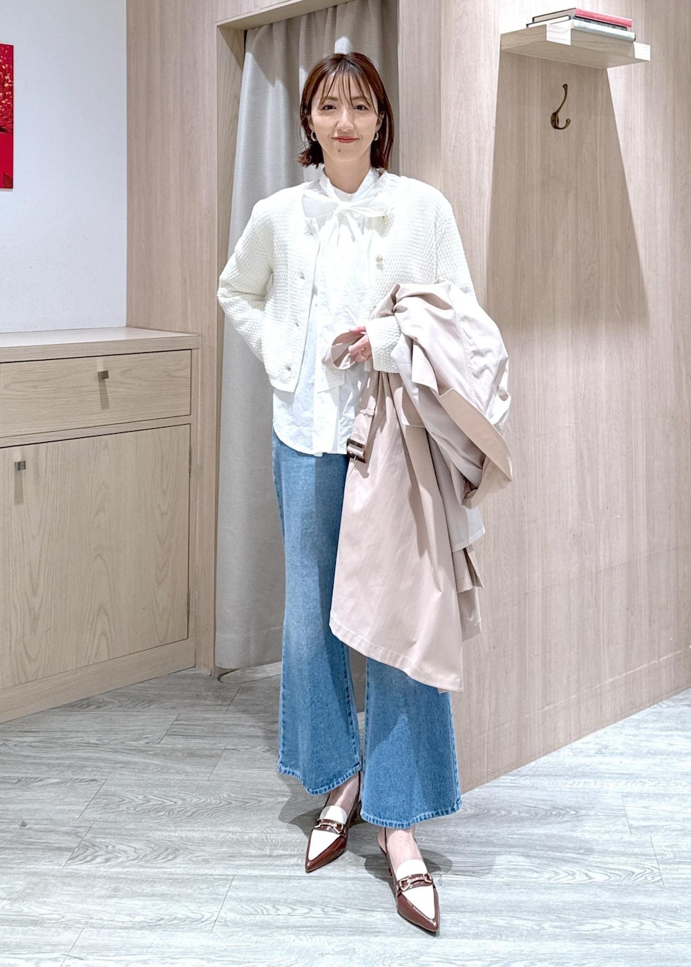 ブラック系のショルダーバッグ、ベージュ系のトレンチコート、ホワイト系のカーディガン/ボレロを着用したレディースの春コーディネートの6枚目の写真