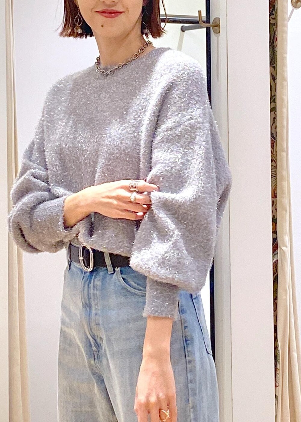 ブラック系のパンプス、グレー系のニット/セーター、ブルー系のデニムパンツを着用したレディースの冬コーディネートの9枚目の写真