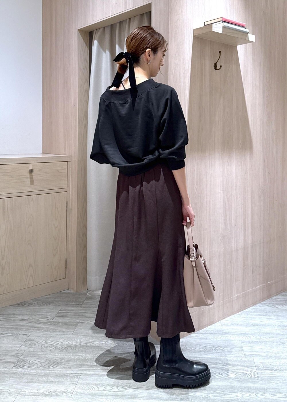 ブラック系のキャミソール、ブラウン系のスカート、ブラック系のブーツを着用したレディースの秋コーディネートの3枚目の写真