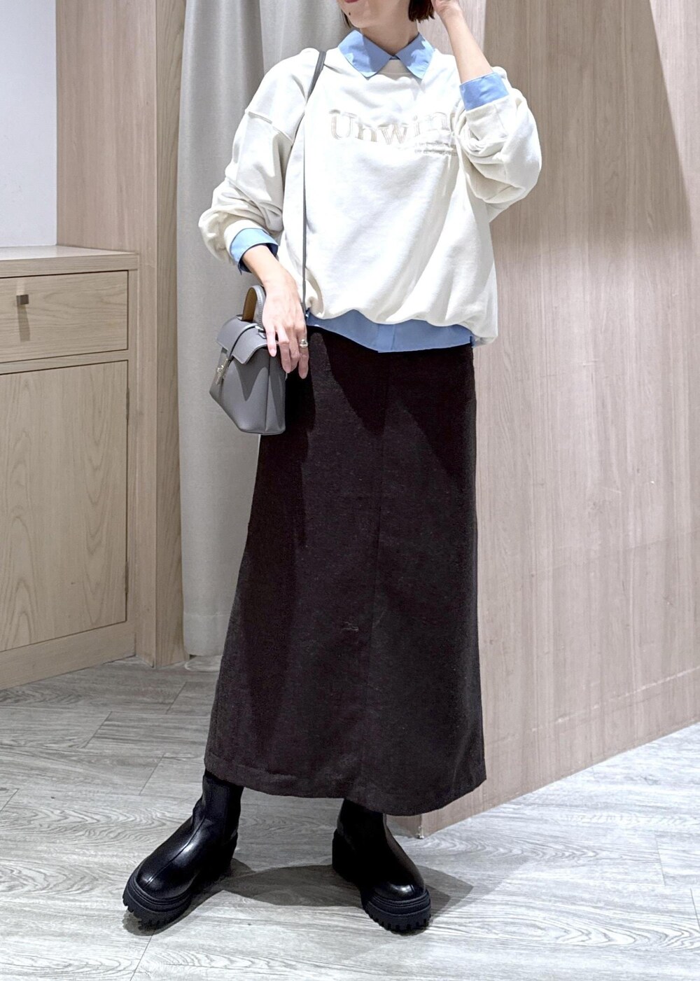 グレー系のショルダーバッグ、ブラック系のブーツ、ブラウン系のスカートを着用したレディースの秋コーディネートの10枚目の写真