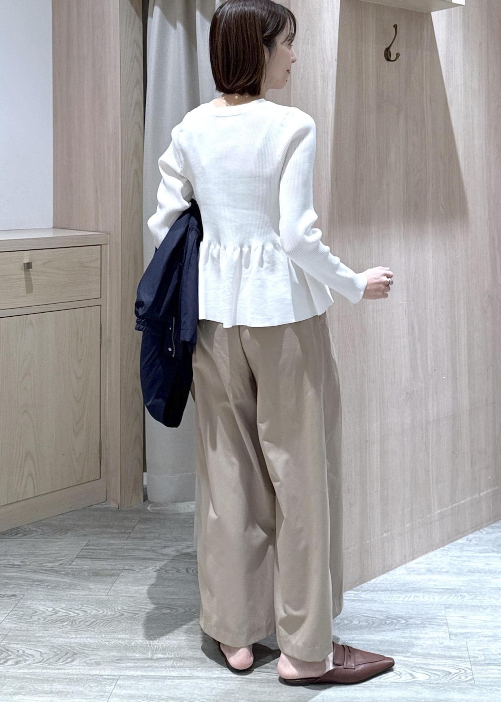 ホワイト系のカーディガン/ボレロ、ホワイト系のトートバッグ、ブルー系のナイロンジャケットを着用したレディースの春コーディネートの9枚目の写真