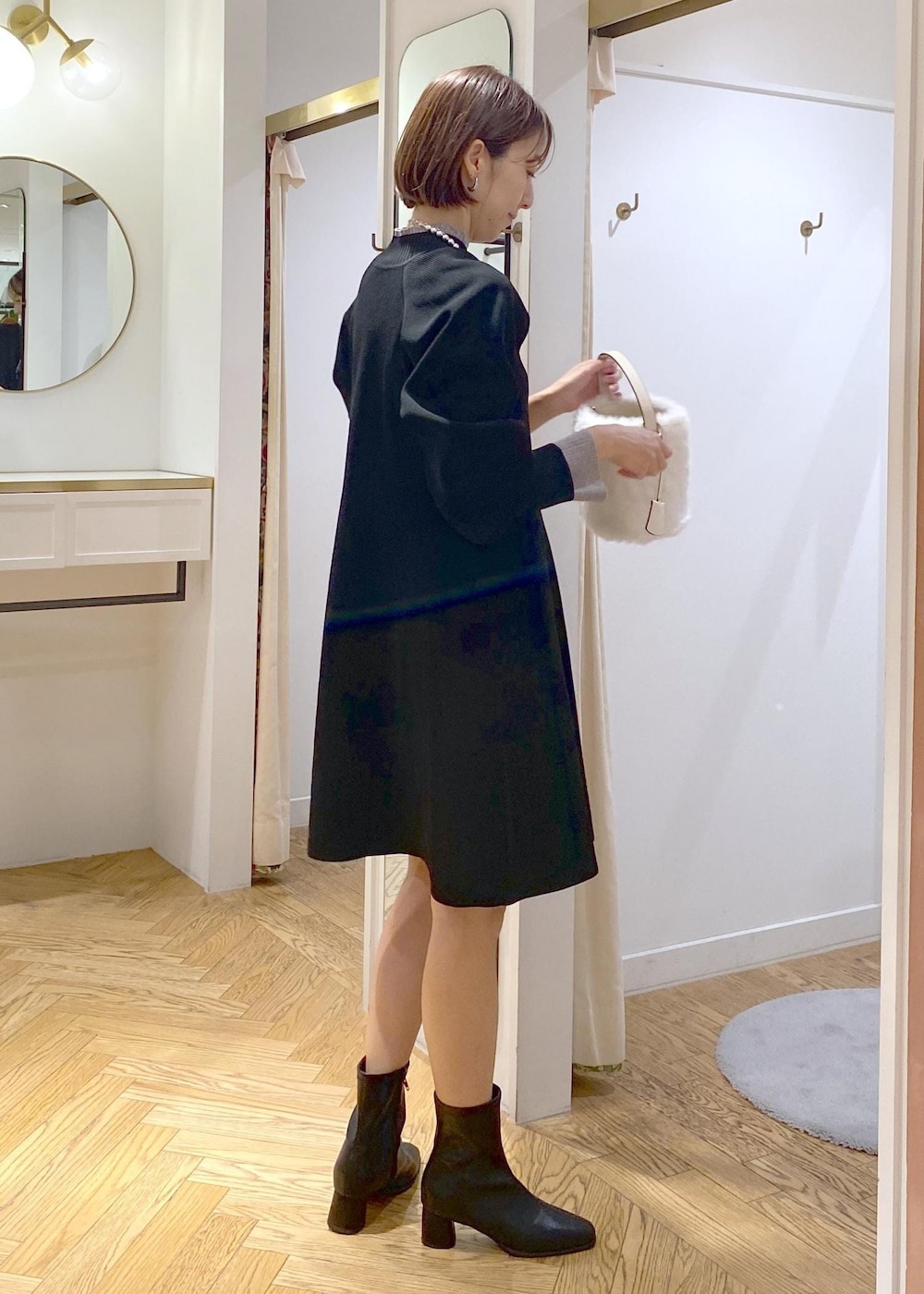 ブラック系のブーツ、ブラック系のワンピース、グレー系のニット/セーターを着用したレディースの秋コーディネートの4枚目の写真